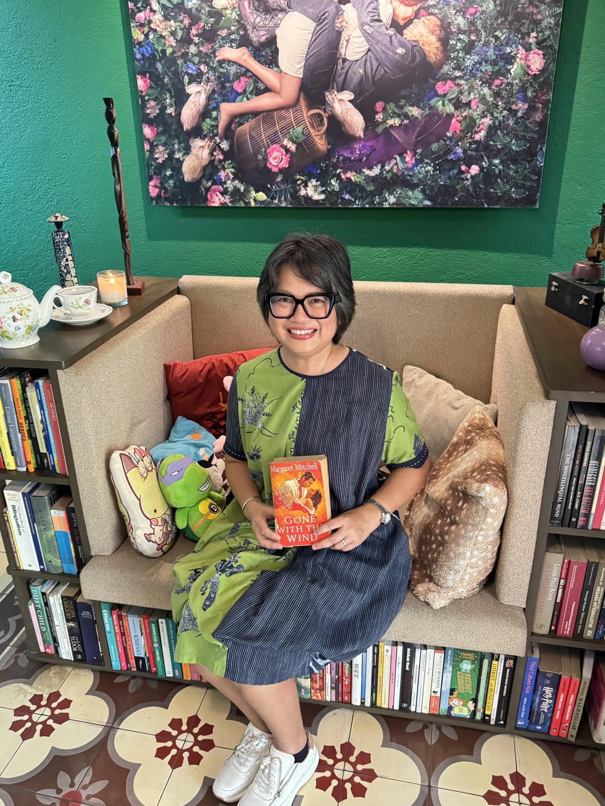 Dr Santi holding a book in a reading space